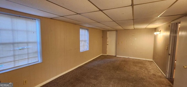 spare room featuring a paneled ceiling, carpet, and a healthy amount of sunlight