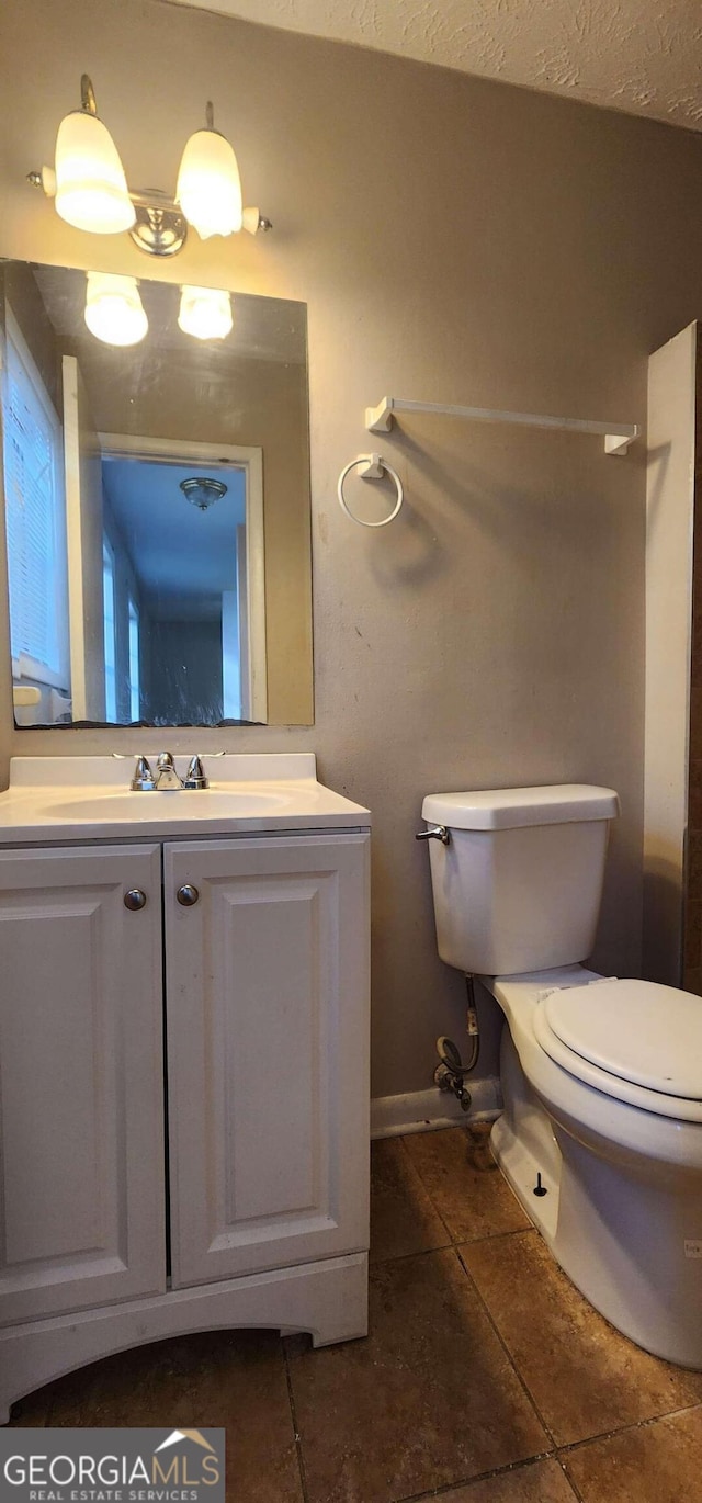 bathroom with tile patterned flooring, vanity, and toilet