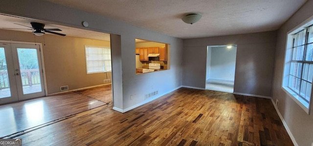 unfurnished room with french doors, a textured ceiling, hardwood / wood-style flooring, and ceiling fan