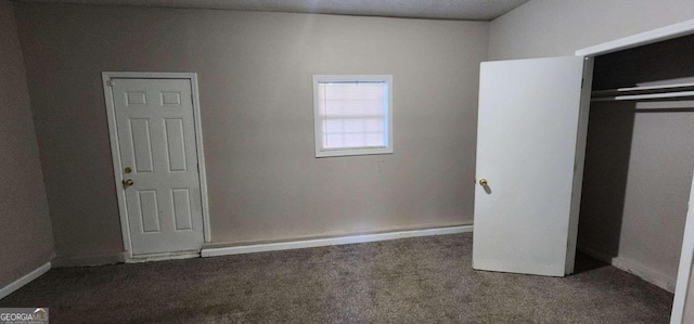 unfurnished bedroom with carpet flooring, a textured ceiling, and a closet