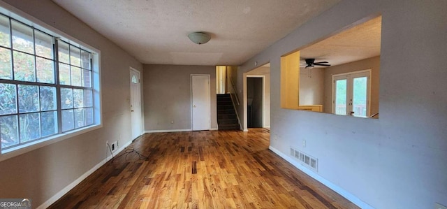 corridor featuring wood-type flooring and a textured ceiling