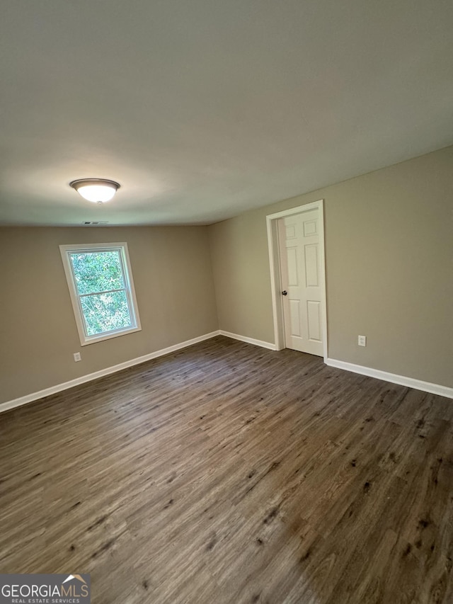 empty room featuring dark wood-type flooring