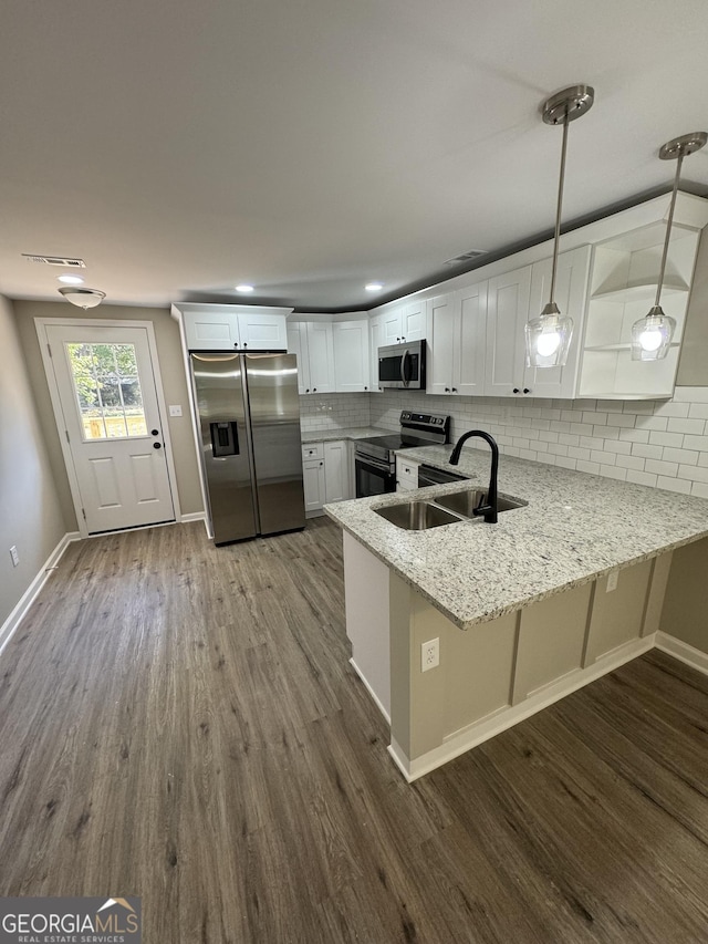 kitchen featuring sink, kitchen peninsula, white cabinets, and appliances with stainless steel finishes