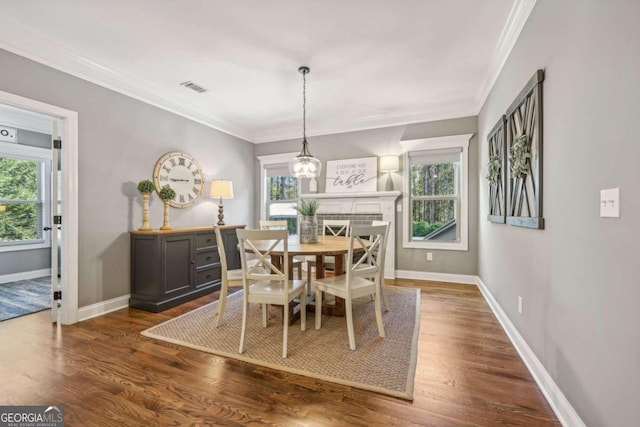 dining room with dark hardwood / wood-style flooring, crown molding, and an inviting chandelier