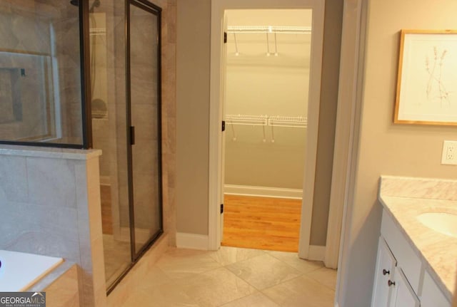 bathroom with vanity, wood-type flooring, and shower with separate bathtub