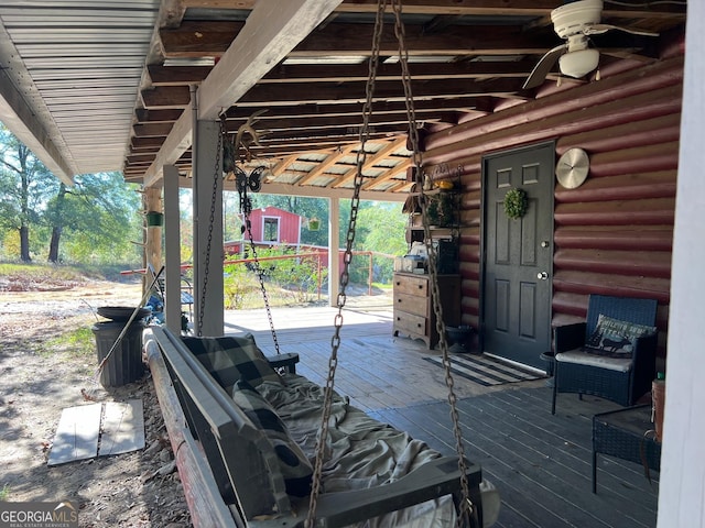 view of patio featuring ceiling fan, an outdoor structure, and a wooden deck