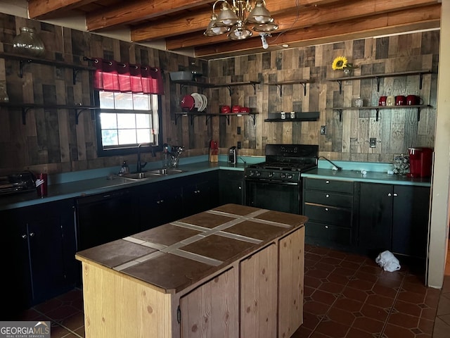 kitchen with an inviting chandelier, sink, dark tile patterned floors, beamed ceiling, and gas stove