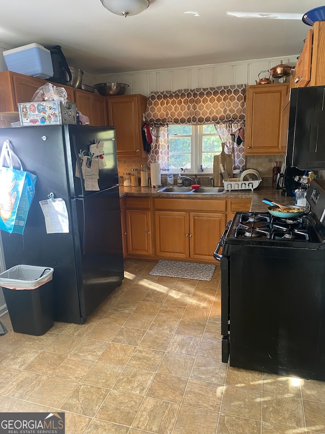 kitchen featuring sink, tasteful backsplash, and black appliances