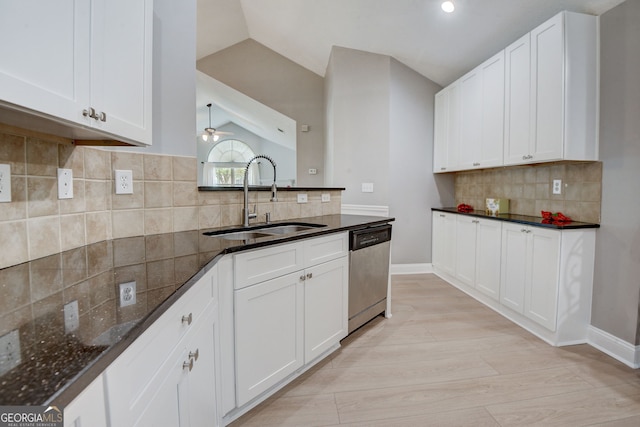 kitchen featuring dishwasher, sink, white cabinets, and lofted ceiling