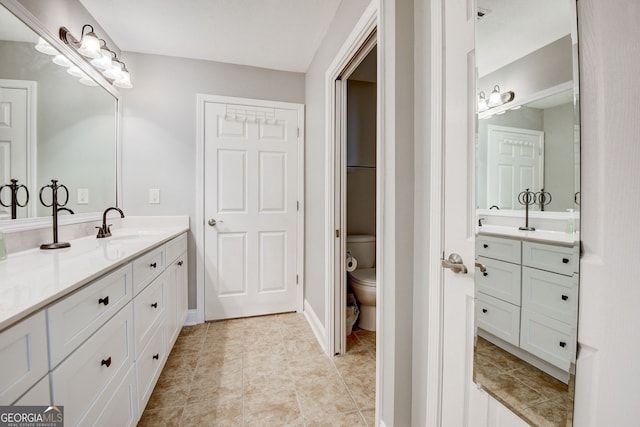 bathroom featuring tile patterned flooring, vanity, and toilet