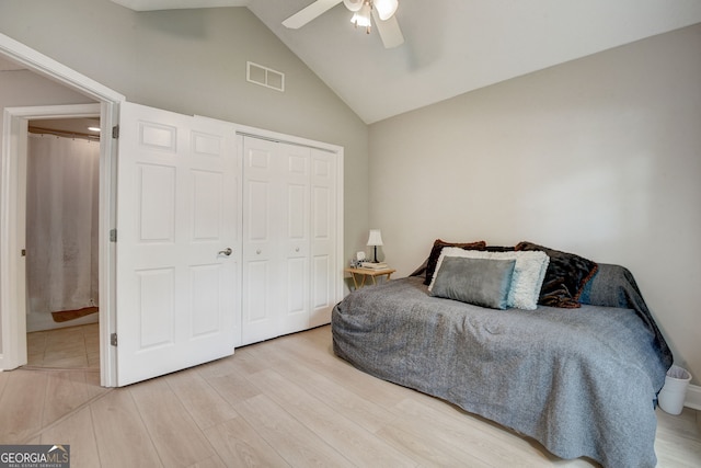 bedroom featuring high vaulted ceiling, a closet, light hardwood / wood-style flooring, and ceiling fan