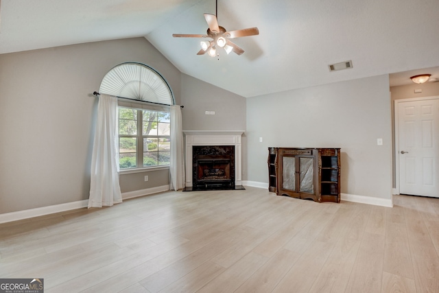 unfurnished living room with ceiling fan, light hardwood / wood-style floors, lofted ceiling, and a high end fireplace