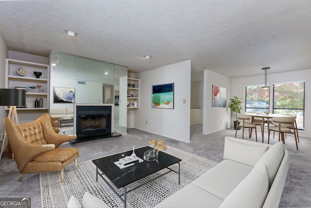 carpeted living room with built in features and a textured ceiling