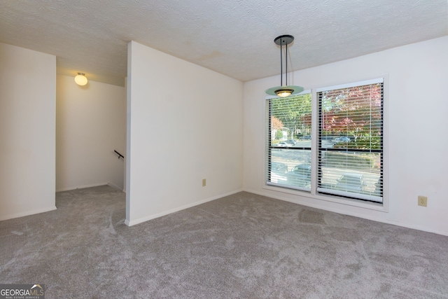 carpeted empty room with a textured ceiling