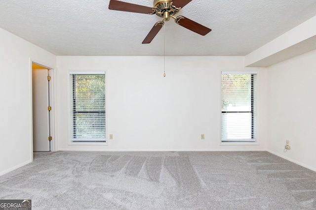 spare room featuring light carpet, plenty of natural light, ceiling fan, and a textured ceiling