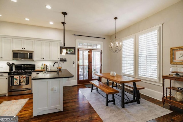 kitchen featuring pendant lighting, sink, white cabinets, and stainless steel appliances