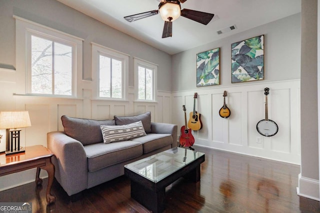 living room with ceiling fan and dark hardwood / wood-style flooring