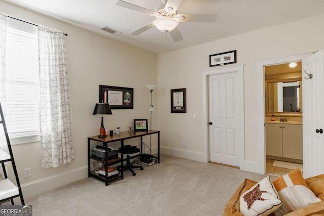 home office with ceiling fan and light carpet