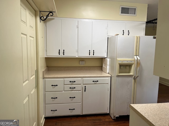 kitchen featuring white cabinets, dark wood-type flooring, and white refrigerator with ice dispenser