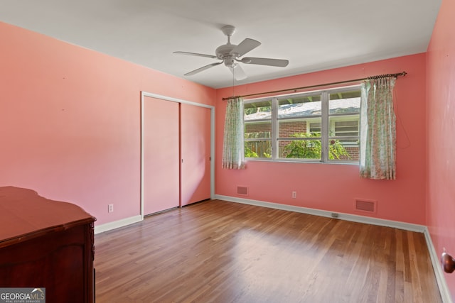 unfurnished bedroom featuring a closet, light hardwood / wood-style flooring, and ceiling fan