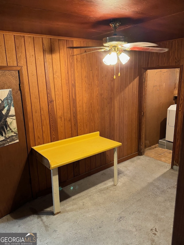 dining space with ceiling fan, wood walls, and washer / clothes dryer