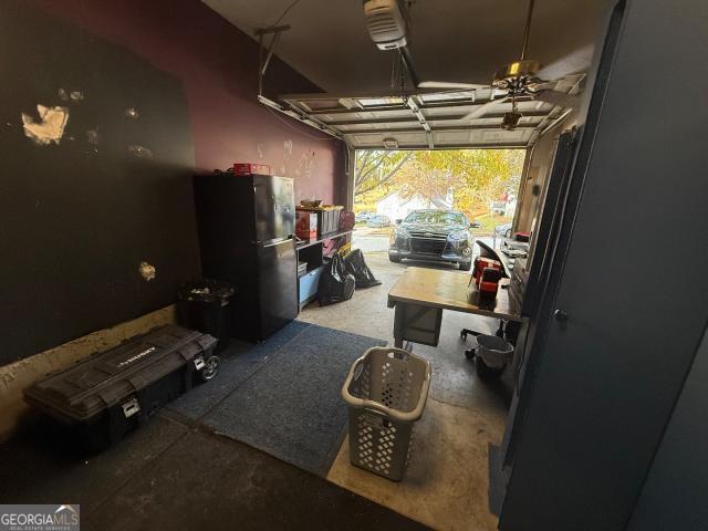 garage with black refrigerator and ceiling fan