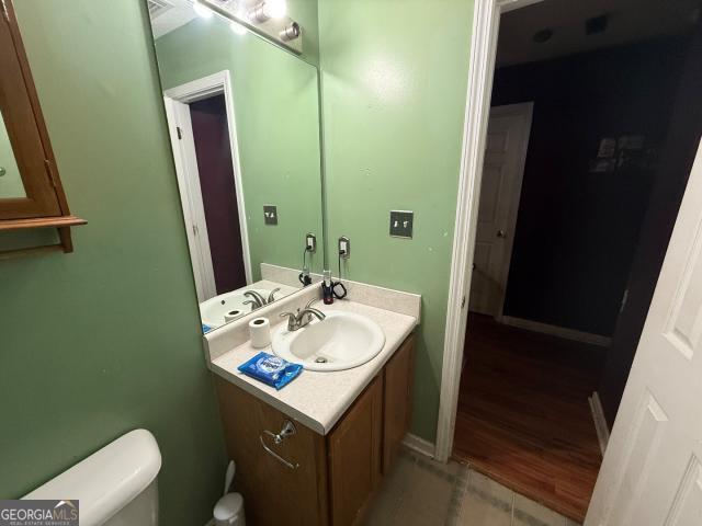 bathroom featuring vanity, wood-type flooring, and toilet