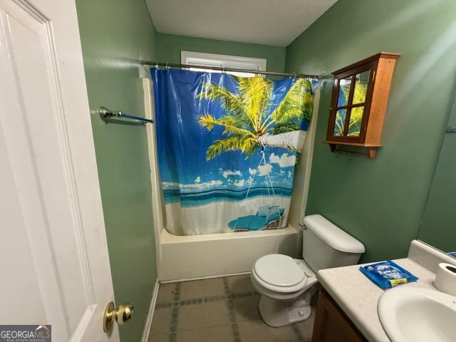 full bathroom featuring shower / bath combo with shower curtain, vanity, toilet, and a healthy amount of sunlight