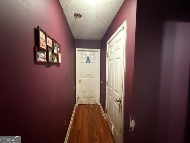 hall featuring hardwood / wood-style flooring and a textured ceiling