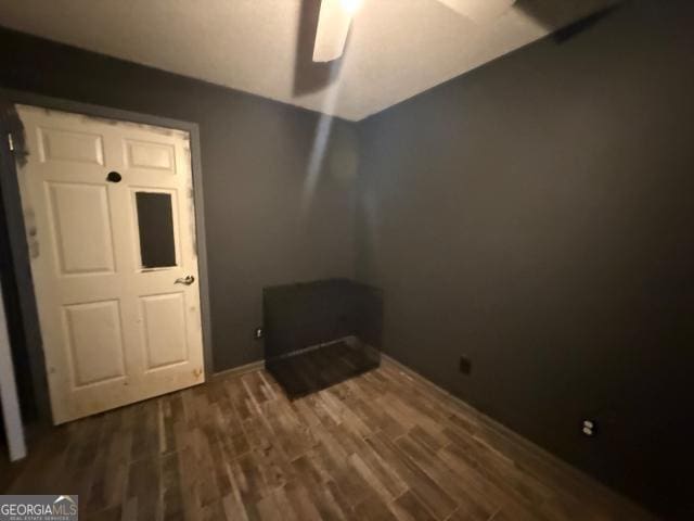 unfurnished bedroom featuring dark hardwood / wood-style floors and ceiling fan