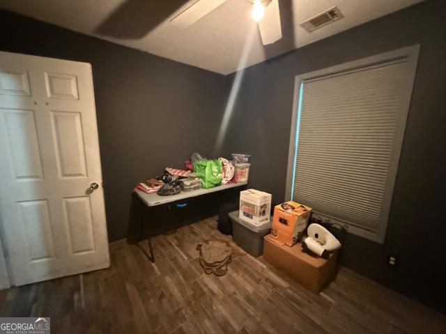 interior space featuring ceiling fan and dark wood-type flooring