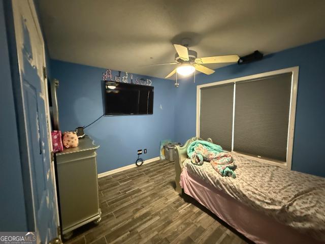 bedroom featuring ceiling fan, dark hardwood / wood-style flooring, and a closet