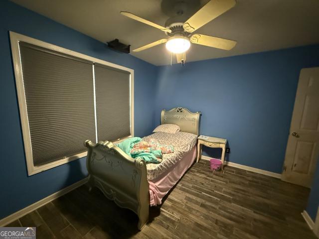 bedroom with ceiling fan and dark wood-type flooring