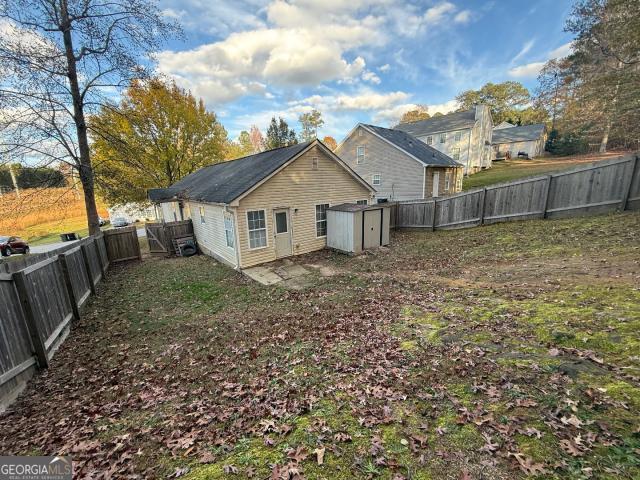 back of house featuring a storage shed