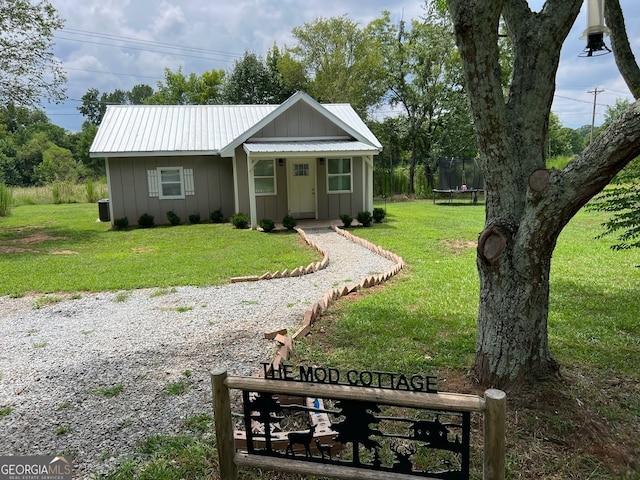 single story home featuring a front yard and a trampoline