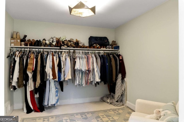 walk in closet with light carpet