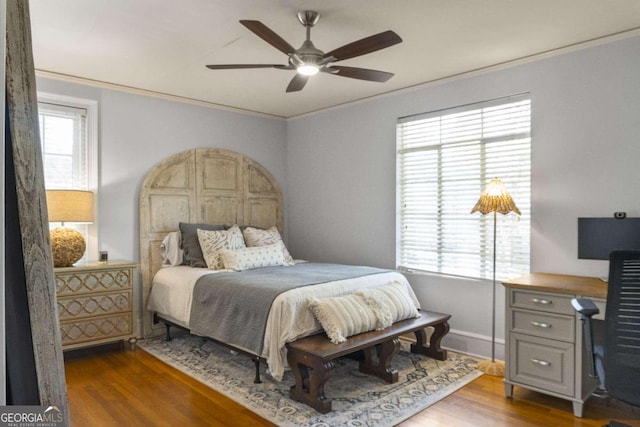 bedroom with multiple windows, dark hardwood / wood-style flooring, and ceiling fan