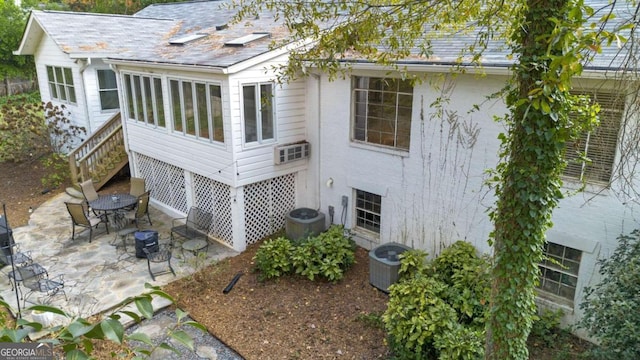 back of property with central AC and a patio area