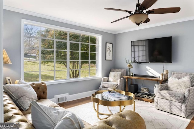 living room featuring hardwood / wood-style flooring, plenty of natural light, and crown molding