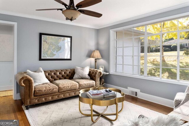 living room with ceiling fan, wood-type flooring, and ornamental molding