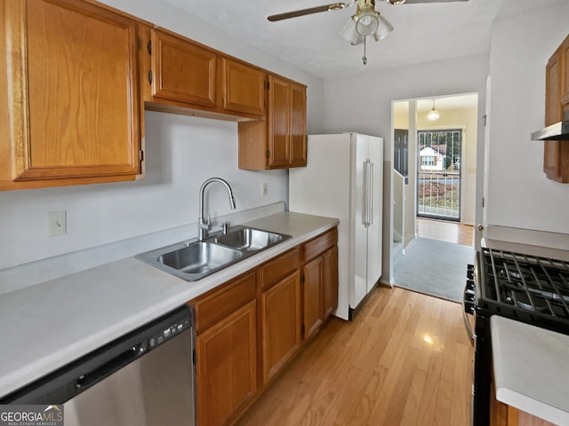 kitchen with dishwasher, sink, range with gas cooktop, white refrigerator, and light wood-type flooring