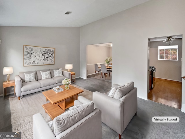 living room with dark hardwood / wood-style floors, ceiling fan, and vaulted ceiling