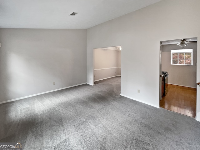 empty room featuring dark hardwood / wood-style floors, ceiling fan, and vaulted ceiling