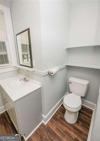 bathroom featuring vanity, wood-type flooring, and toilet