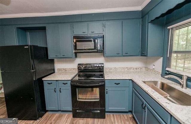 kitchen featuring blue cabinetry, sink, and black appliances