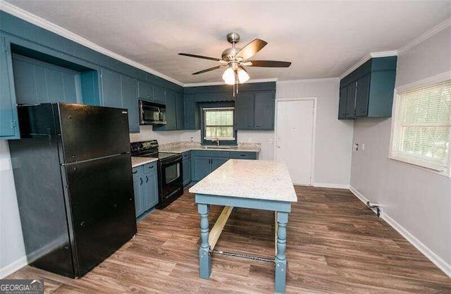 kitchen featuring dark hardwood / wood-style flooring, crown molding, sink, blue cabinetry, and black appliances