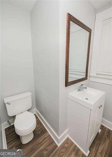 bathroom featuring wood-type flooring, vanity, and toilet