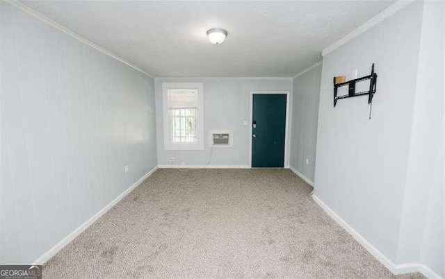 carpeted empty room featuring a wall mounted air conditioner and ornamental molding