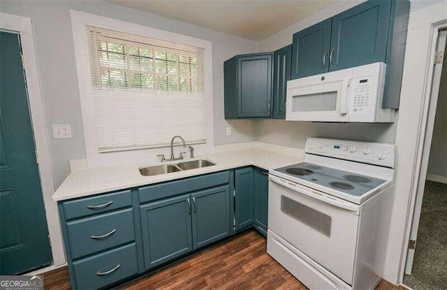 kitchen with white appliances, blue cabinets, dark wood-type flooring, and sink