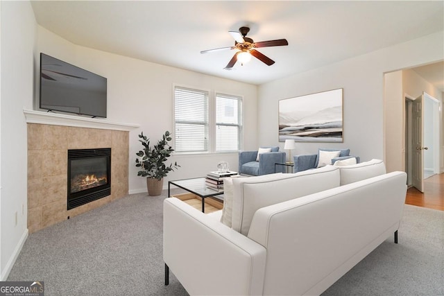 carpeted living room with a fireplace and ceiling fan